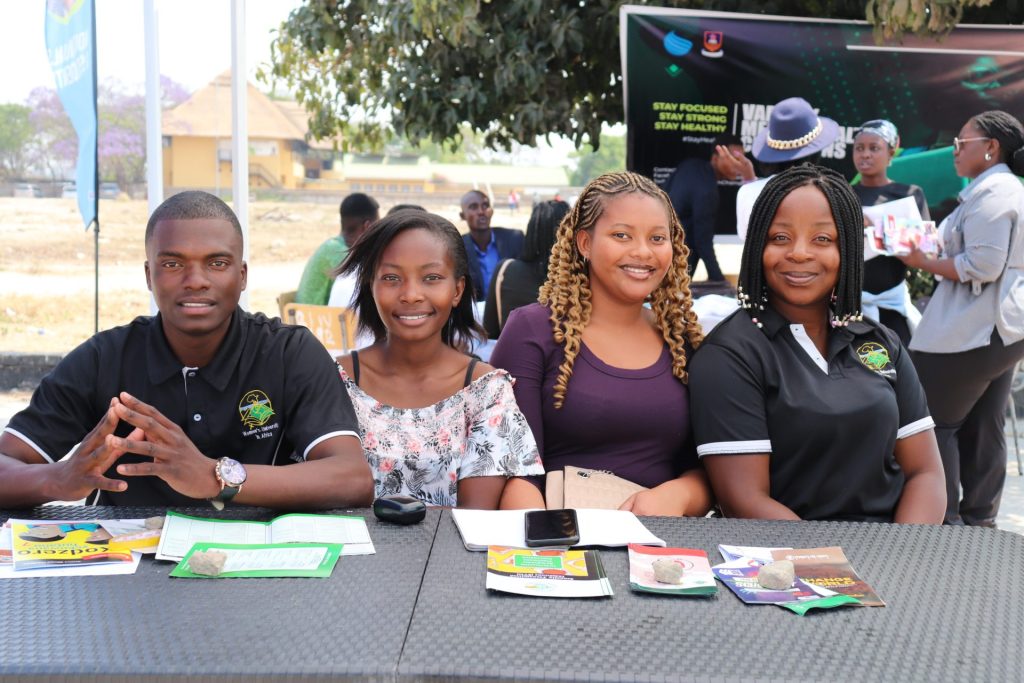 WUA community members welcoming visitors at an outdoor information stand.